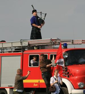 Dudelsackspieler Axel Römer auf einem Feuerwehrwagen – Eine Aktion an der Himmelgeister Kastanie